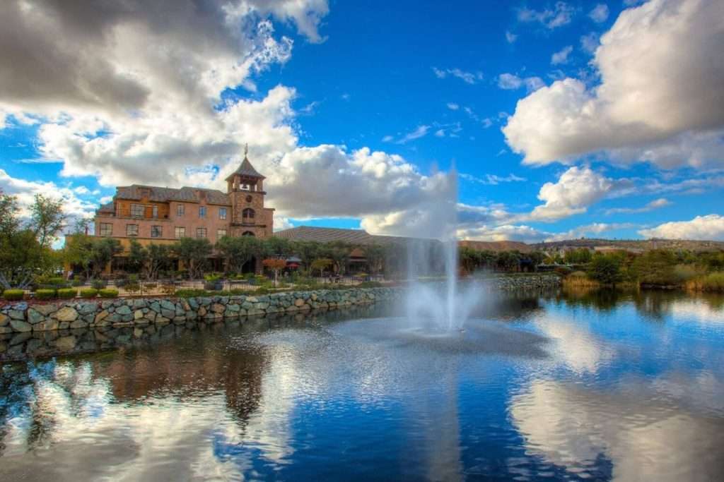 Otterbine Aquastar fountain spraying water in front of a large stone building