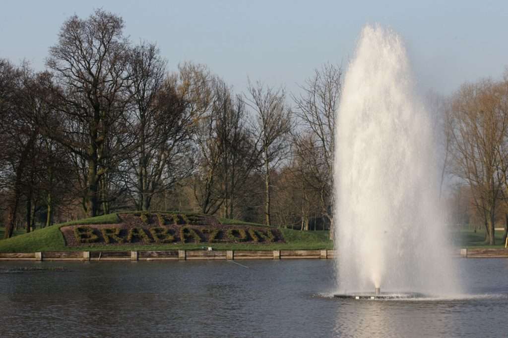 Otterbine Polaris fountain spraying water high in front of trees and 'The Brabazon' landscape sign