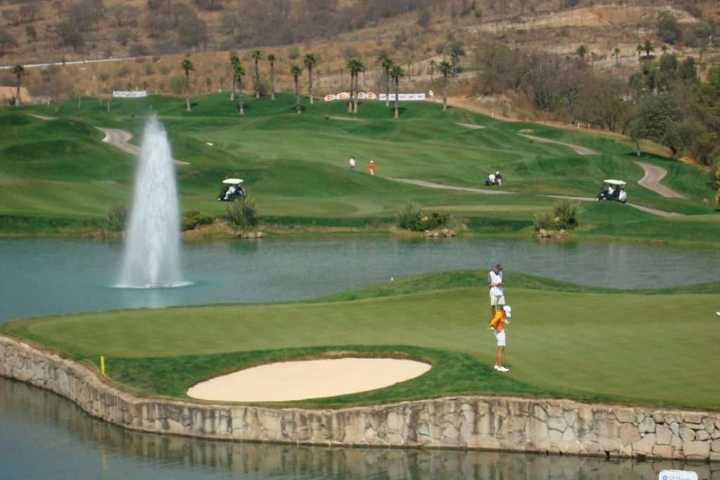 Otterbine Polaris fountain aerating a lake on a golf course with golfers and palm trees in the background