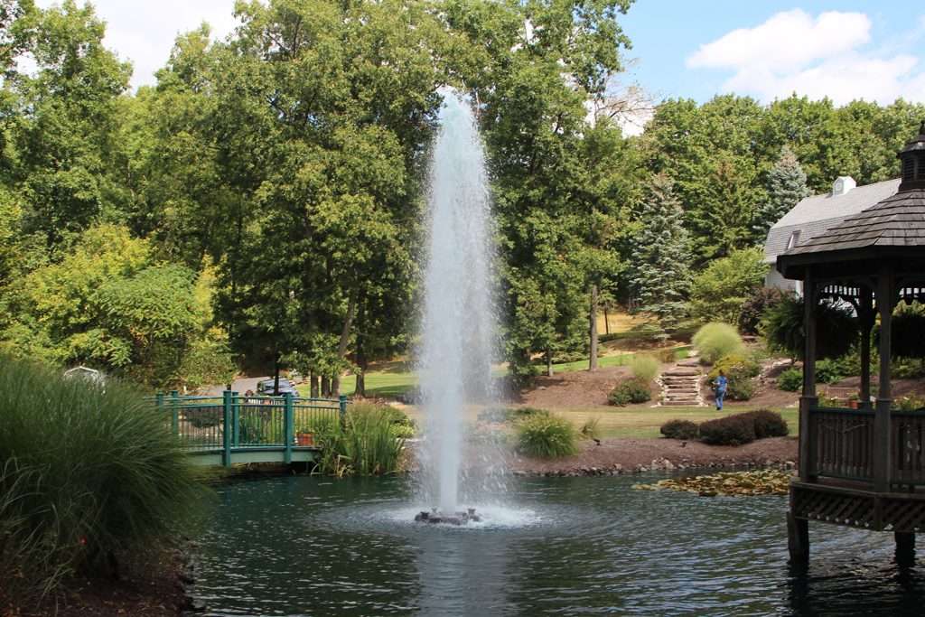 Park fountain surrounded by trees and gazebo.