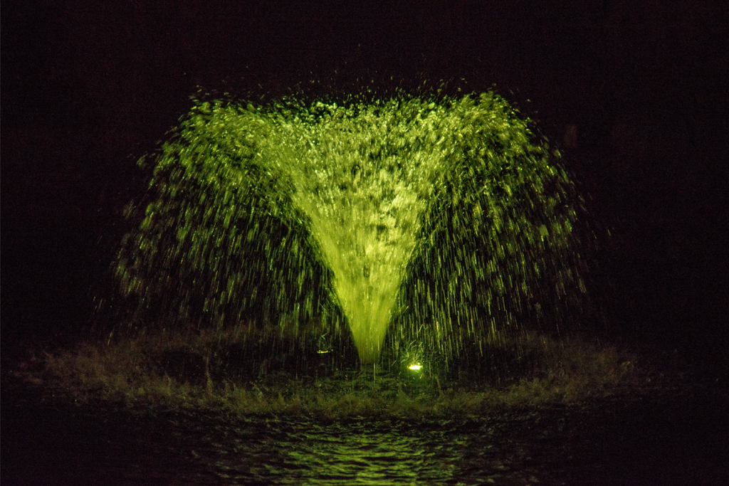 Otterbine Mini-RGBW fountain producing glowing yellow water display at night