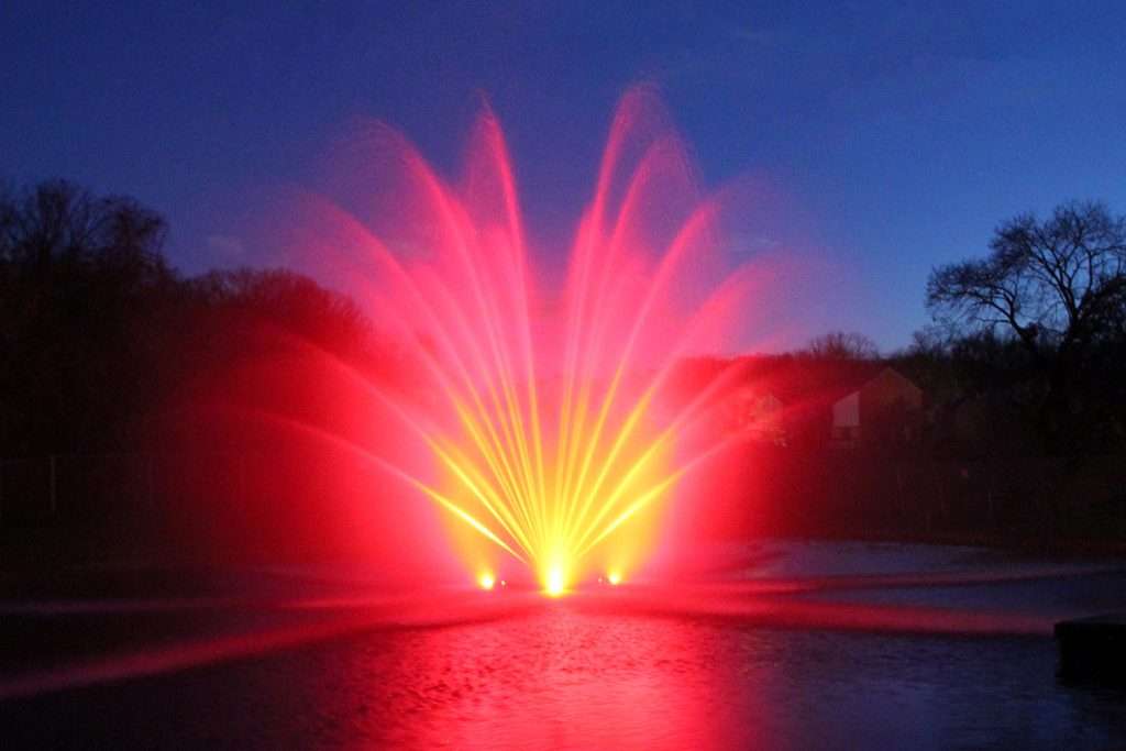 Red illuminated RGBW fountain display at dusk in Australia