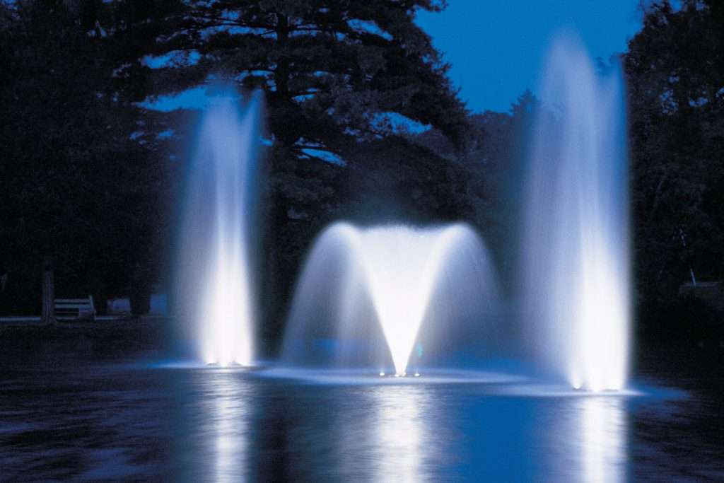 Otterbine Rocket fountains illuminated at night with multiple tall water sprays